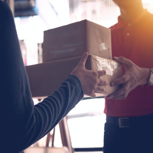 Delivery man in red delivering two boxes