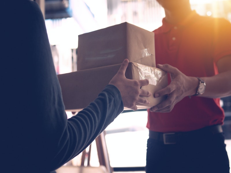 Delivery man in red delivering two boxes