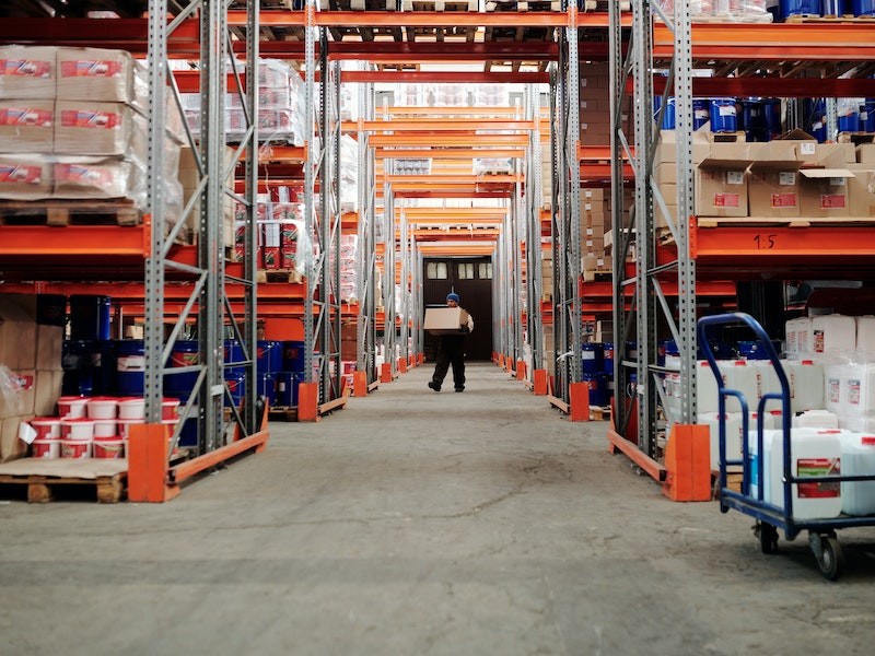 Man in distance carrying a box in a warehouse