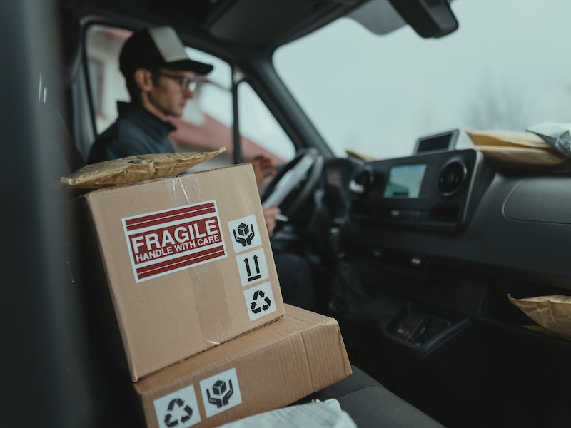 Fragile packages on the seat next to delivery man