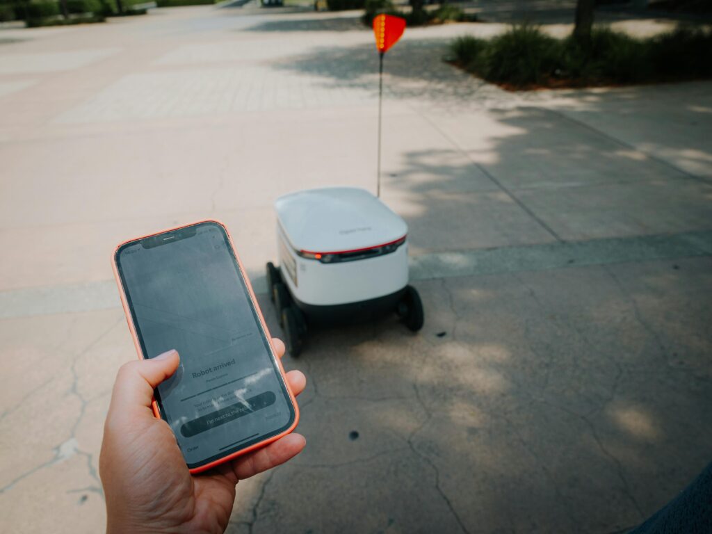 Man holding mobile phone with autonomous drone in background